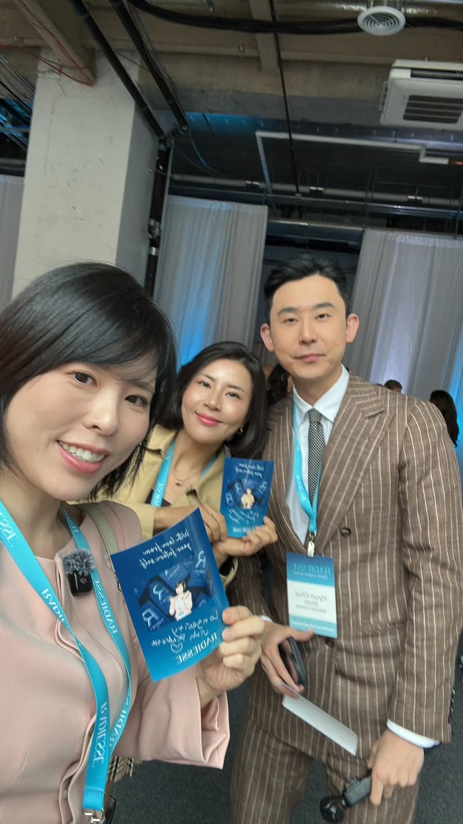 원문 학회 현장 단체 사진 — 책 표지·작은 이름표 판독 한계