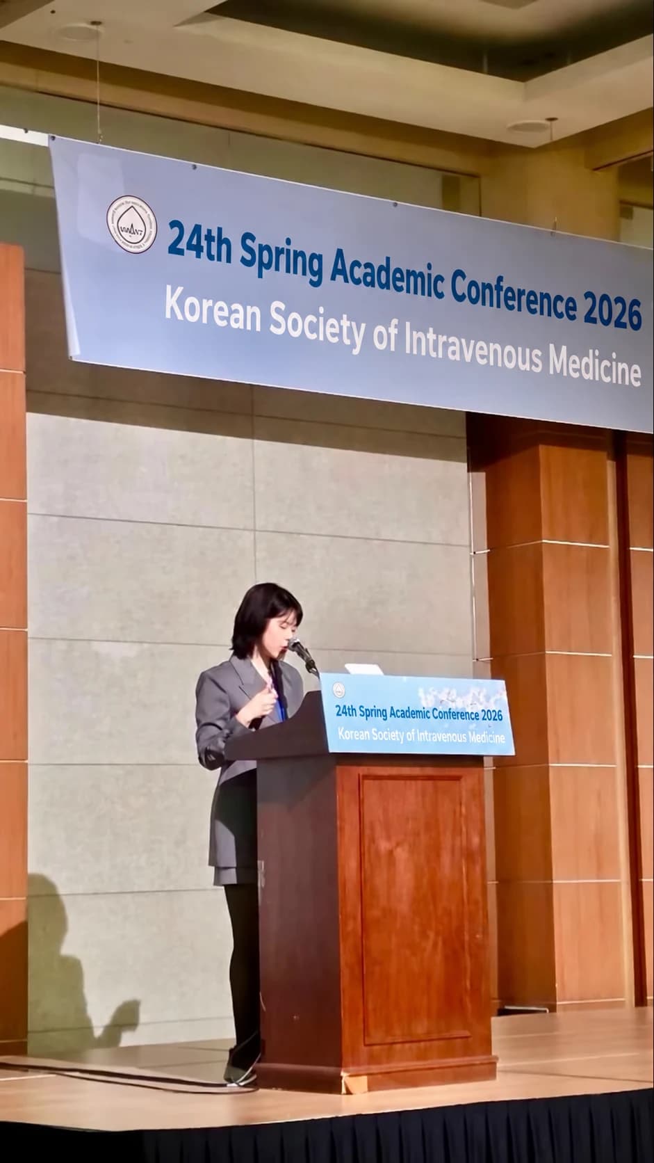 Conference presentation photograph — AI-assisted English text adaptation; not an unedited medical original